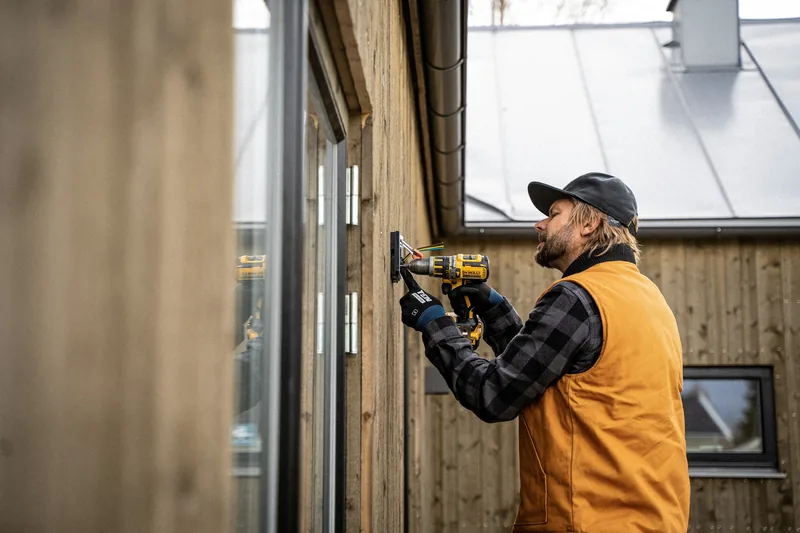 Eltekniker som arbetar med ett styrsystem